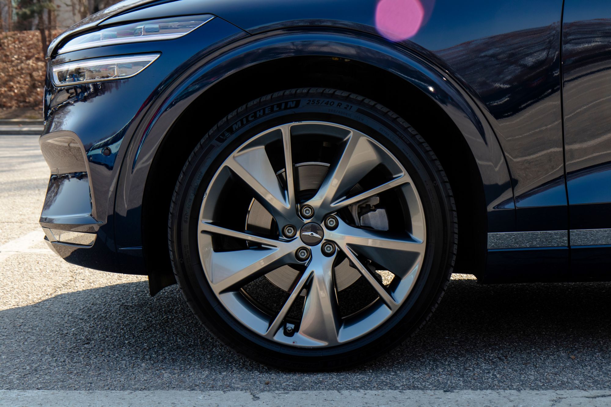 Front wheel of a dark blue Genesis with the brake rotor visible through the spokes