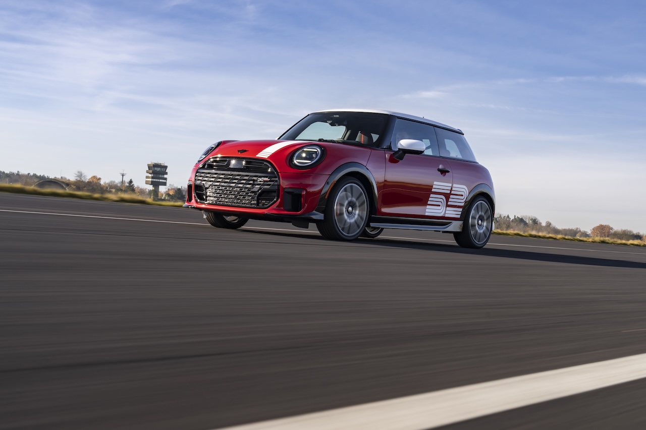 2026 MINI 1965 Victory Edition JCW in Chili Red driving toward camera, available at MINI of Freeport in Freeport, NY