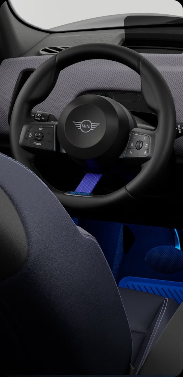 Detail view of the 2026 MINI Countryman Untamed Edition cabin featuring Cornflower Blue steering wheel strap and Nightshade Blue JCW Sport Seat upholstery